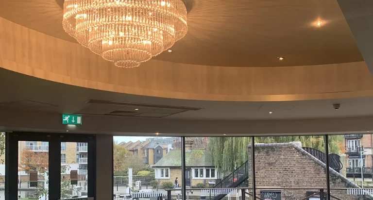 Hotel interior with a large gold chandelier and city view windows