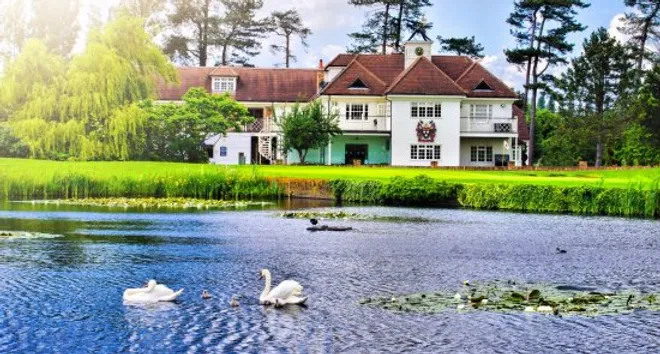Manor house venue exterior overlooking a lake with swans