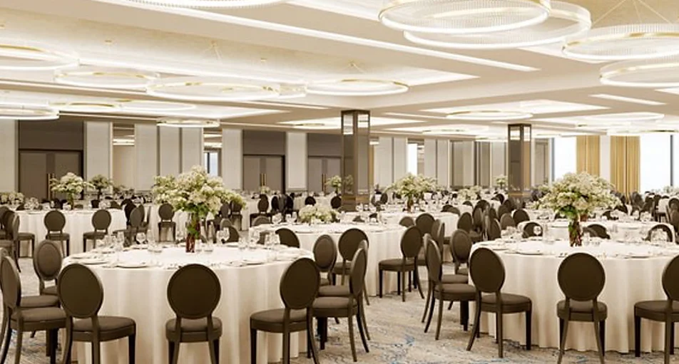 Modern banquet hall with round tables, white flower centrepieces and a domed ceiling