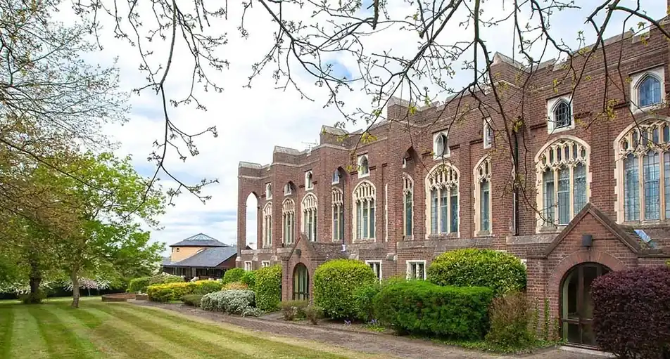 Red brick gothic-style venue building exterior with a manicured lawn