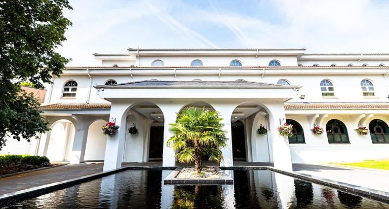 Grand wedding venue building exterior with a reflecting pool