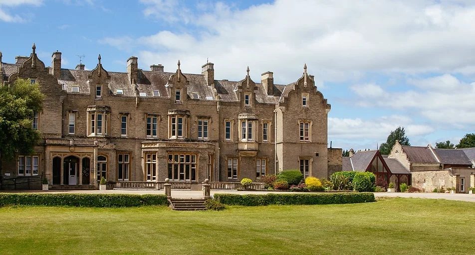 Manor house wedding venue viewed through a garden gate