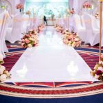 Wedding aisle decorated with floral arrangements leading to the stage