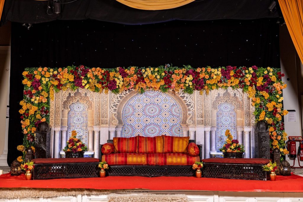 Wedding Decoration 7 Wedding stage decorated with a vibrant orange and red floral arch