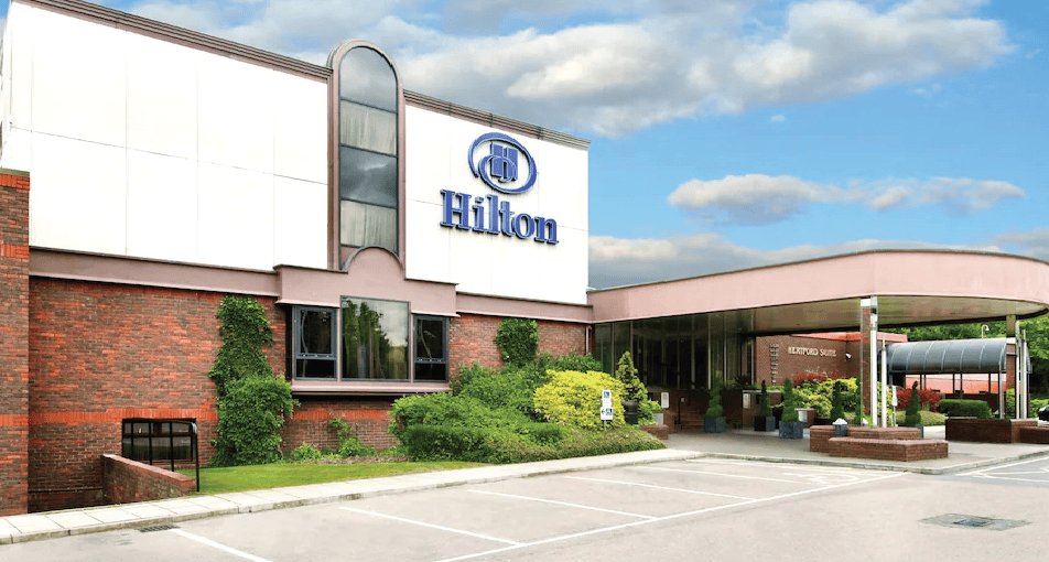 Hilton hotel exterior building with parking lot and landscaping
