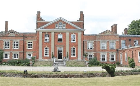 Red brick manor house wedding venue set on an open lawn