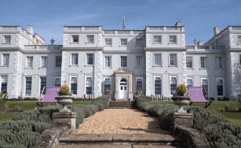 White Georgian mansion wedding venue exterior with a lawn and pathway
