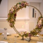 Gold hoop floral centrepiece with pink roses displayed on a wedding table