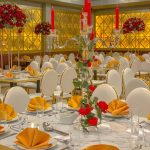 Gold-themed wedding table setting with a floral centrepiece