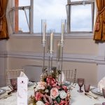 Elegant wedding table centrepiece with white florals and candles