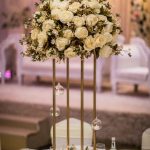 Tall white and cream floral centrepiece on a gold stand