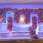 Wedding stage decorated with red and white floral arrangements