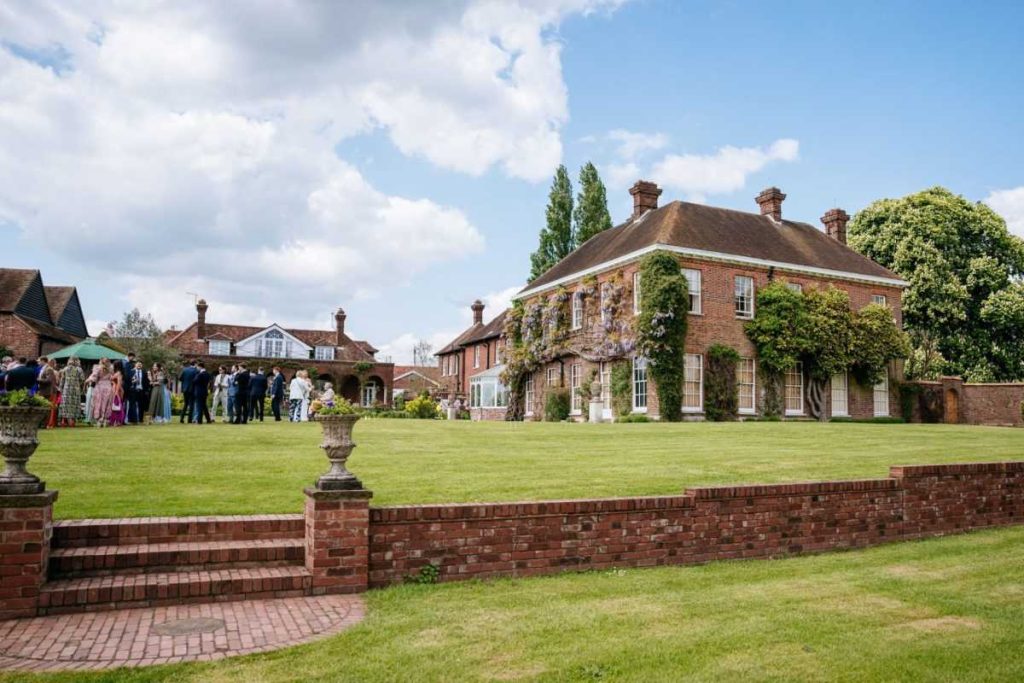 Micklefield Hall (Manor House) 1 Red brick manor house venue with guests gathering on the lawn