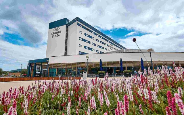Crowne Plaza hotel exterior with colourful flower beds in the foreground