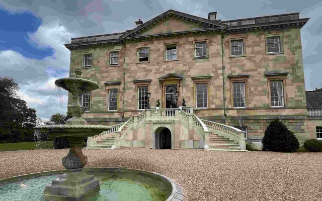 Stone mansion venue exterior with a fountain and grand staircase entrance
