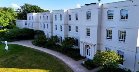 White venue building exterior with a landscaped garden pathway